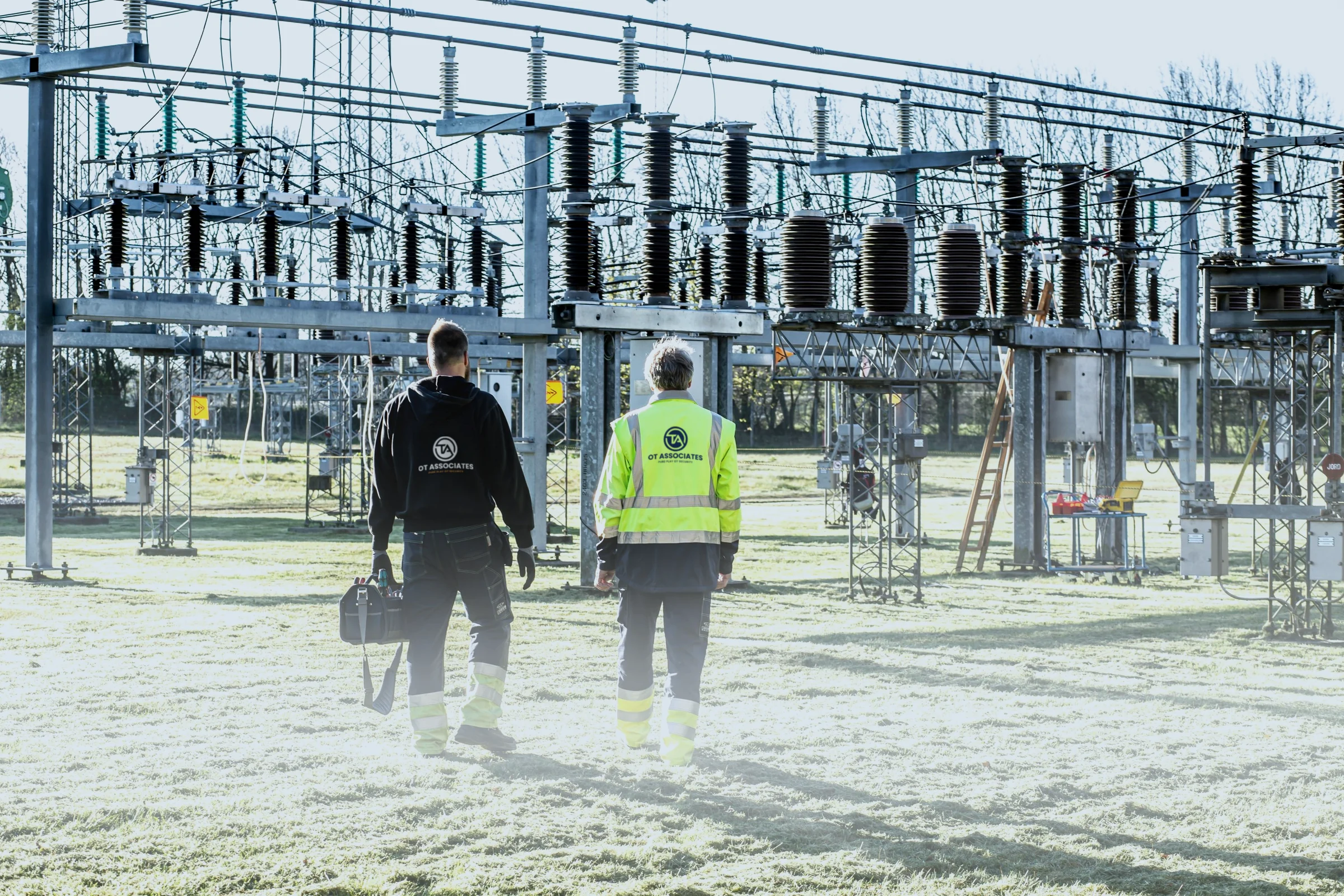 Two OT Associates engineers walking into an electrical substation