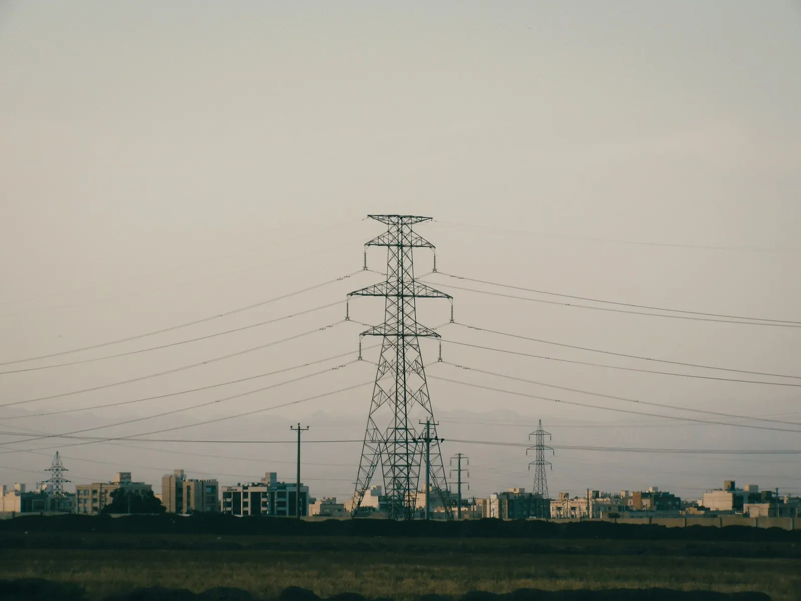 Transmission pylons above a city at night